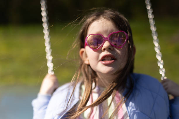 istock Young Girl with Pink Glasses on Swing 1485189330