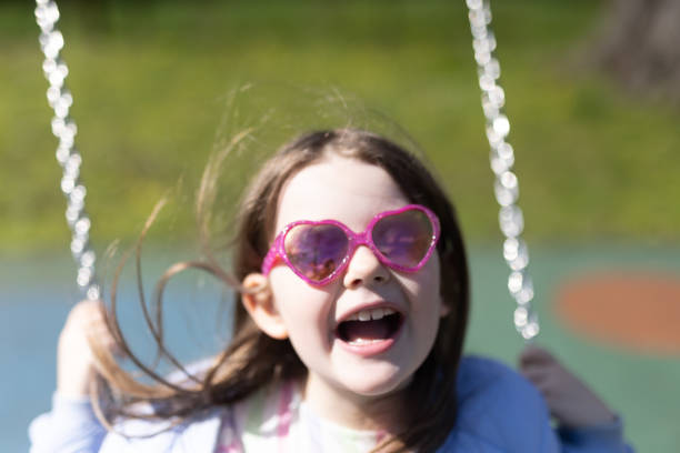 istock Young Girl with Pink Glasses on Swing 1485189345