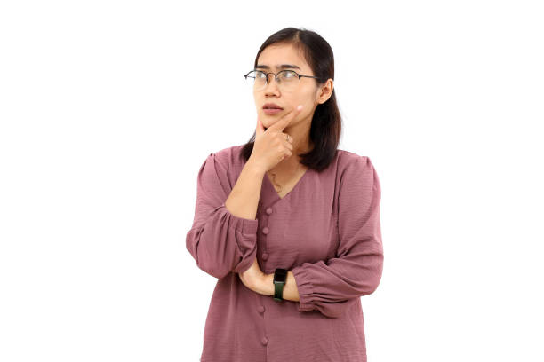 istock Pensive Young asian woman standing while imagining something. Isolated on white background 1485189670
