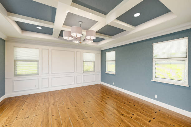 Beautiful Blue-Gray Custom Master Bedroom Complete with Entire Wainscoting Wall, Fresh Paint, Crown and Base Molding, Hard Wood Floors and Coffered Ceiling stock photo