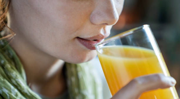 istock Young woman drinking orange juice 1485197130