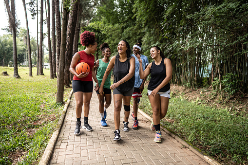 Basketball female friends walking on a public park