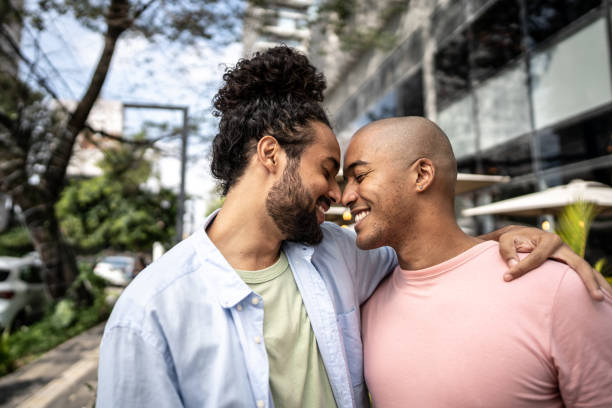 coppia gay che abbraccia nella strada - homosexual gay man symbol homosexual couple foto e immagini stock