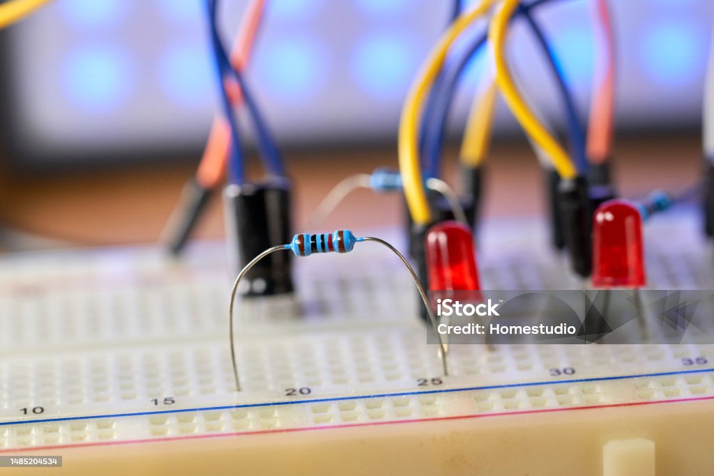 Breadboard with electrical elements, on a wooden table. Bread Stock Photo