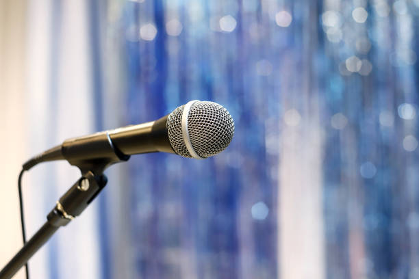istock Microphone on the stage against the blurred blue tinsel background 1485212182