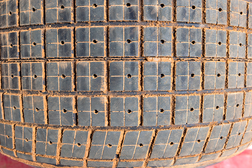 Photograph of the tread and pattern on large rubber speedway race car tyres in the pit area before being put on the car for racing on a dirt track