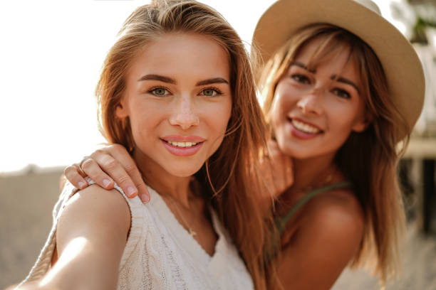 istock Two happy girlfriends making selfie, smiling, having fun together. Sunny summer light. Sisters. 1485214579