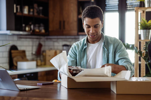 istock A smiling young man is unboxing an online purchase at home 1485217490
