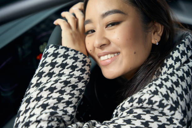 istock Smiling young woman sitting behind the wheel 1485220064
