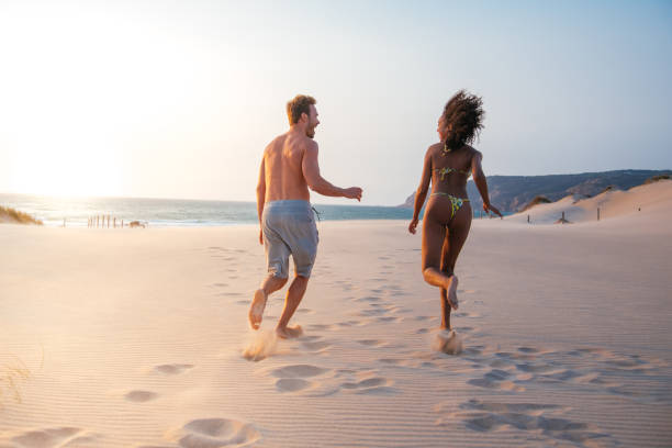 istock Happy couple running on tropical romantic beach 1485220311