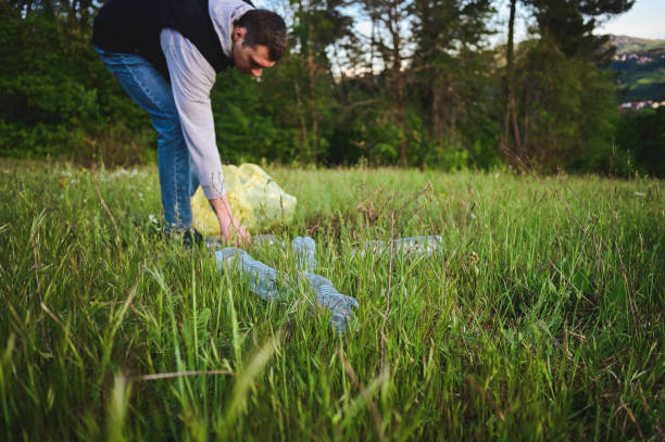 istock man collecting plastic litter in bucket. 1485223288
