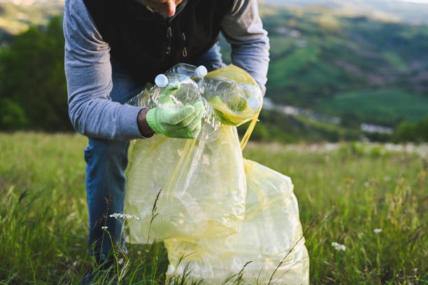 istock unrecognizable man picking up bottle into garbage bag 1485223823
