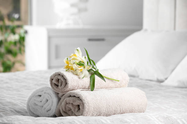 istock Terry towels with beautiful flowers on bed indoors, space for text 1485223838