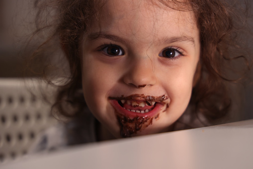 Little girl face covered in chocolate