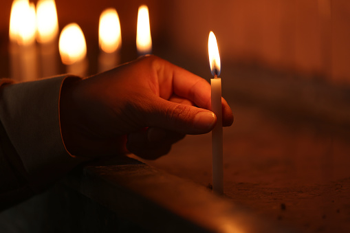 Woman lights candles in church