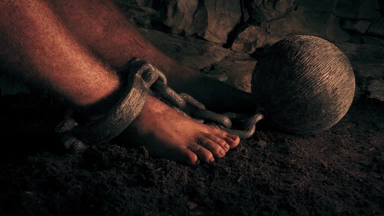 Prisoner Sits With Ball And Chain At Sunset