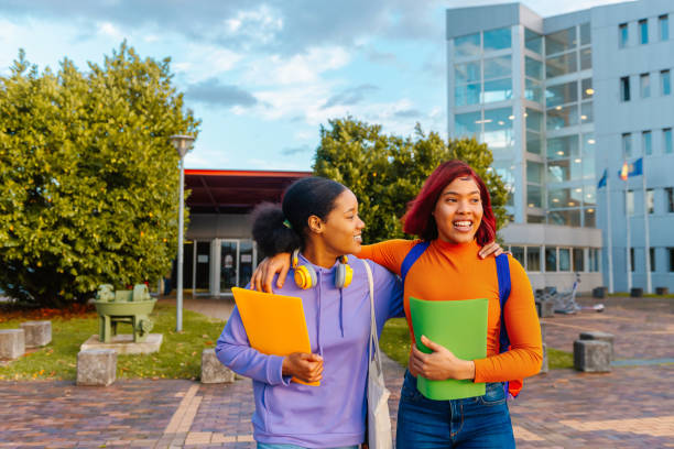 teenage girls at school two teenage latina friends leaving high school together. friendship and unity. after school. puerto rican ethnicity stock pictures, royalty-free photos & images