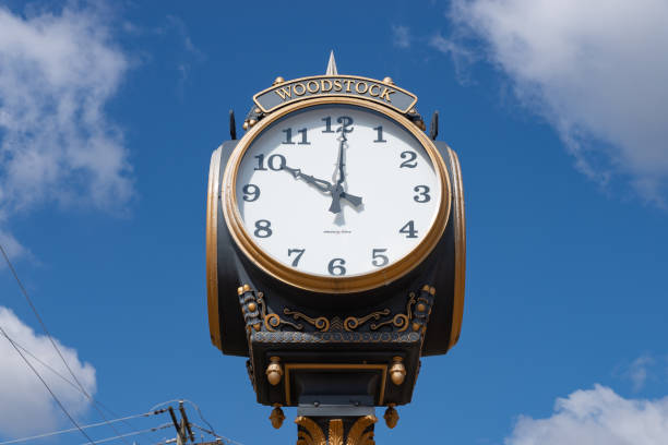 Town Clock Woodstock, Illinois - United States - April 24th, 2023: Woodstock town clock with blue skies and clouds in the background. groundhog day clock stock pictures, royalty-free photos & images