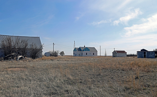 abandoned farm house with out buildings on the prairie