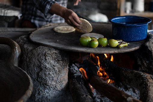 Mexican woman making corn tortillas in a traditional way