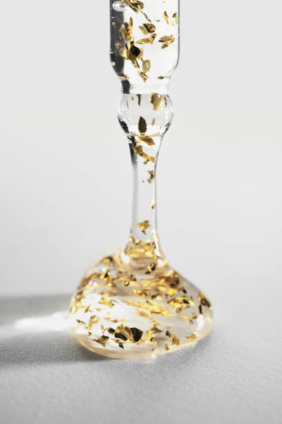 istock Pipette with a leaking drop of cosmetic product with gold particles, selective focus 1485281135