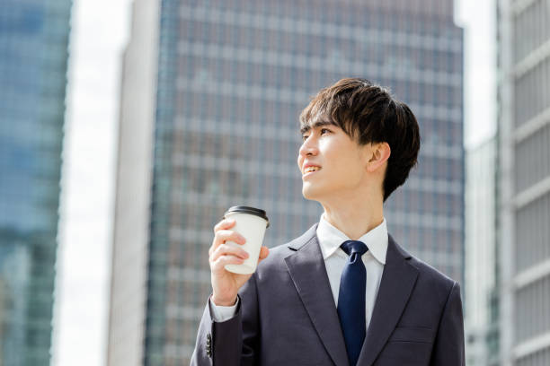istock A man in a suit in his 20s with a take -out coffee with a positive, refreshing and bright expression in a business district 1485289213