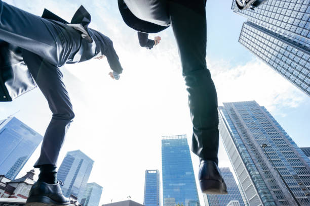 istock Two men in a jumping and dashed suit taken from a low angle in a business district surrounded by buildings 1485292420