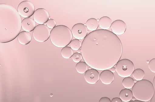 Abstract an art image of oil and water dripping bubbles on rose pink light effect background. Idea for advertising ,logo design, brochure or more use.