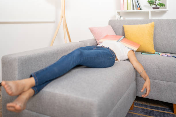 istock Young woman, asleep with her notebook over her face, lying on the sofa 1485297475