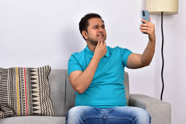 istock Young adult man at home sitting on sofa using smartphone 1485302001