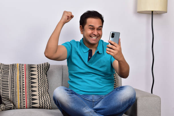 istock Young adult man at home sitting on sofa using smartphone 1485302027