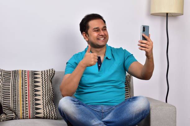 istock Young adult man at home sitting on sofa using smartphone 1485302030