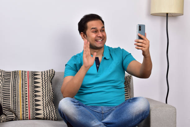 istock Young adult man at home sitting on sofa using smartphone 1485302055
