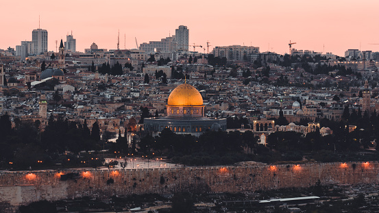 Jerusalem Old Town Cityscape of Temple Mount and Jewish Quarter at Sunset. Holy land view towards the iconic illuminated Al-Aqsa Mosque, Golden Dome of the Rock, Bell Tower of the Church of the Redeemer, Church of the Holy Sepulchre and Old Town City Wall. Jerusalem Old Town, Israel, Middle East.