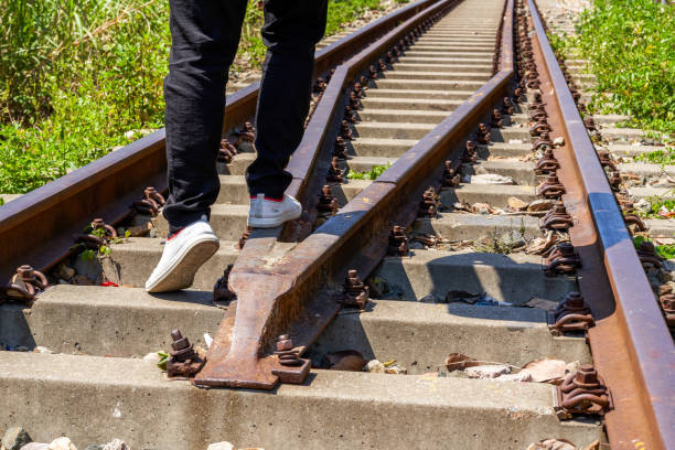 A man walking on old rusty railway tracks outdoors