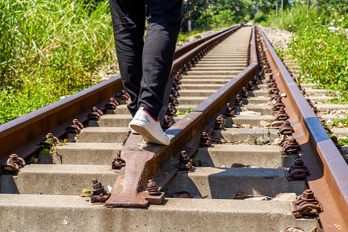 A man walking on old rusty railway tracks outdoors