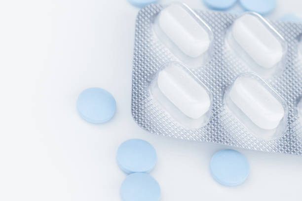 istock White blister pack pills, pharmaceutical product, many blue pills separately on a white background, close-up and selective focus. 1485305934