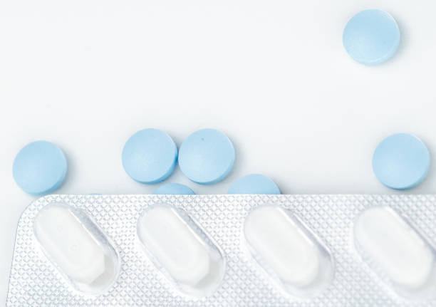 istock Blister pack with white pills over scattered blue pills. View from above. 1485306073