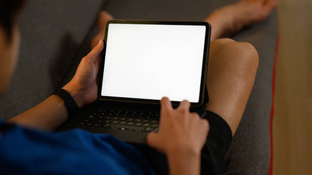 istock Casual man sitting on couch and using digital tablet. Blank screen for montage your graphic display. 1485307571