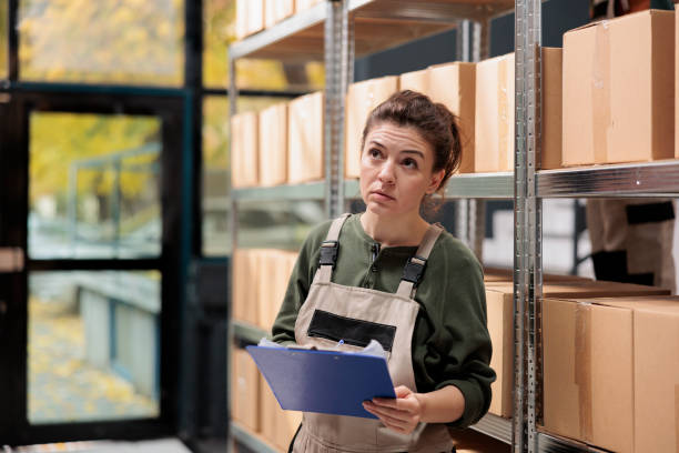 istock Storage room employee looking at cardboard boxes 1485312809