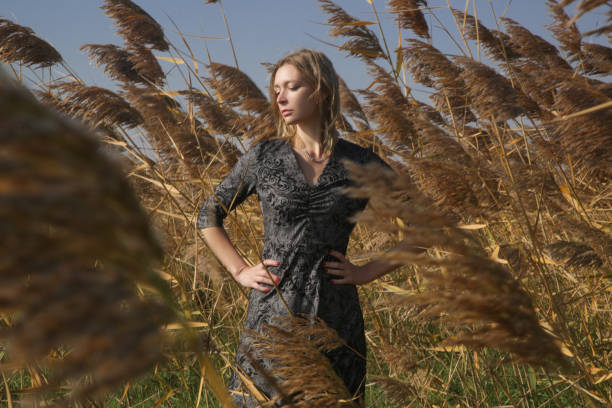 serie di foto di modella femminile in abito a motivi bianchi e neri in posa sul prato. ritratto di moda all'aperto con luce naturale. - meadow single lane road nature field foto e immagini stock