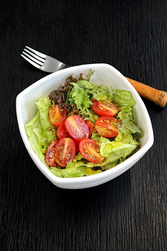 mixed leafy greens with cherry tomatoes and mustard sauce