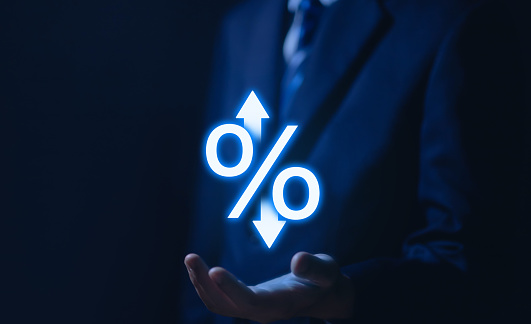 Businessman hand showing percentage icon and up or down arrow rising bank interest rates