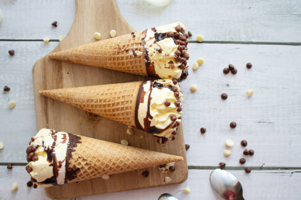 istock Vanilla chocolate ice cream cone. On a white wooden background. Sweets 1485321164