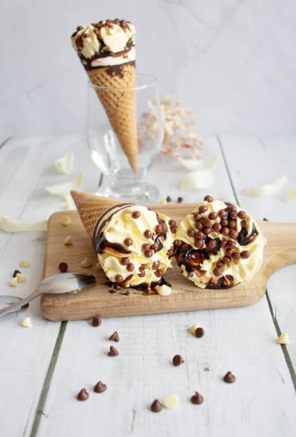 istock Vanilla chocolate ice cream cone. On a white wooden background. Sweets 1485321165