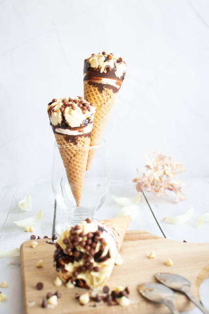 istock Vanilla chocolate ice cream cone. On a white wooden background. Sweets 1485321181