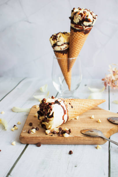 istock Vanilla chocolate ice cream cone. On a white wooden background. Sweets 1485321191