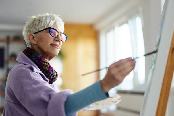 istock Mature female painter enjoying while painting in art studio. 1485322754