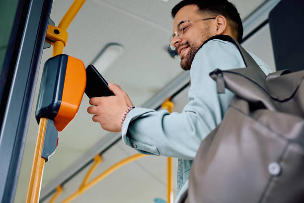istock Below view of man using app on mobile phone while entering in public transport. 1485323996