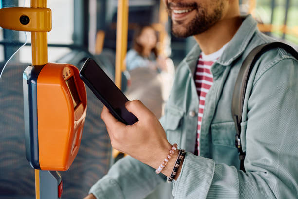 istock Close up of commuter validating card with smart phone while onboarding in a bus 1485324015